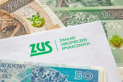 Koperta ZUS na tle polskich banknotów. Pytanie: ile czasu ma pracodawca na wypłacenie chorobowego?