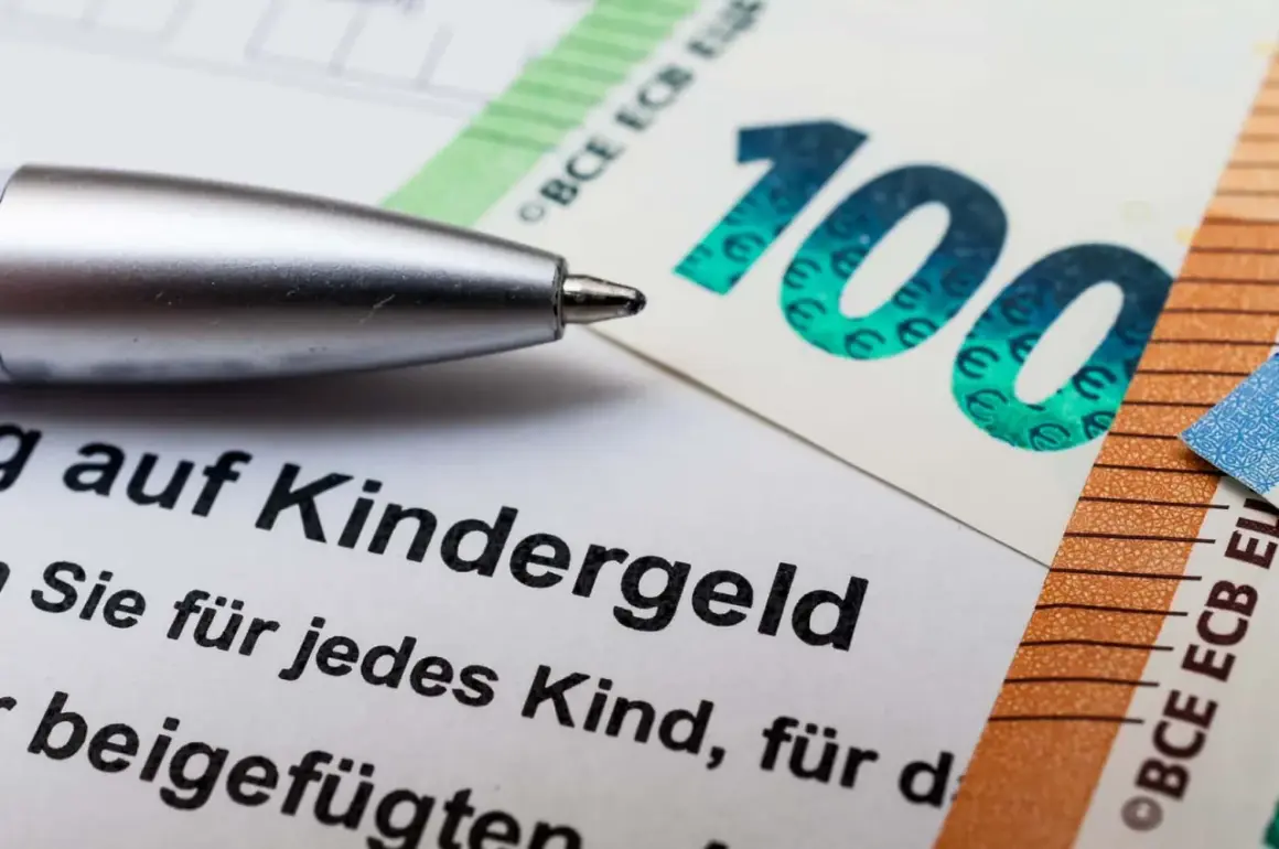 Długopis nad dokumentem o Kindergeld w Niemczech, obok banknotów 100 i 50 euro.