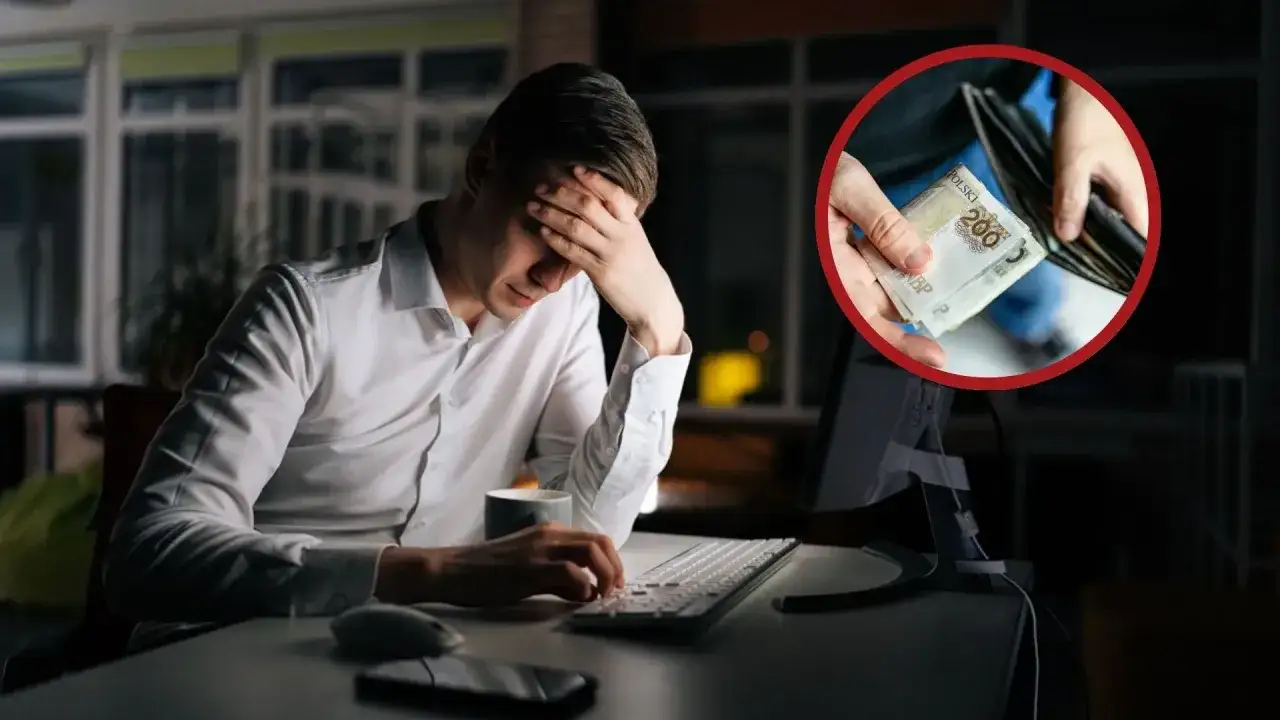 Zmęczony pracownik biurowy przy komputerze, w dłoniach trzyma pieniądze. Czy dodatek za drugą zmianę jest wystarczający?